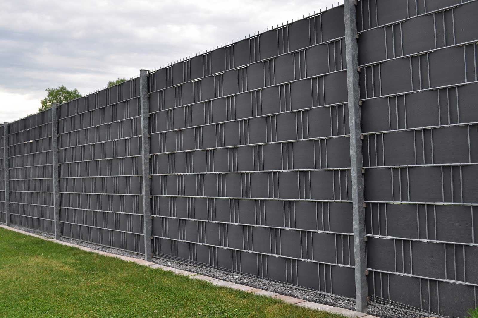 Fertiger Sichtschutzzaun und Gartenanlage von Bazid Daoud GaLaBau in der Abenddämmerung