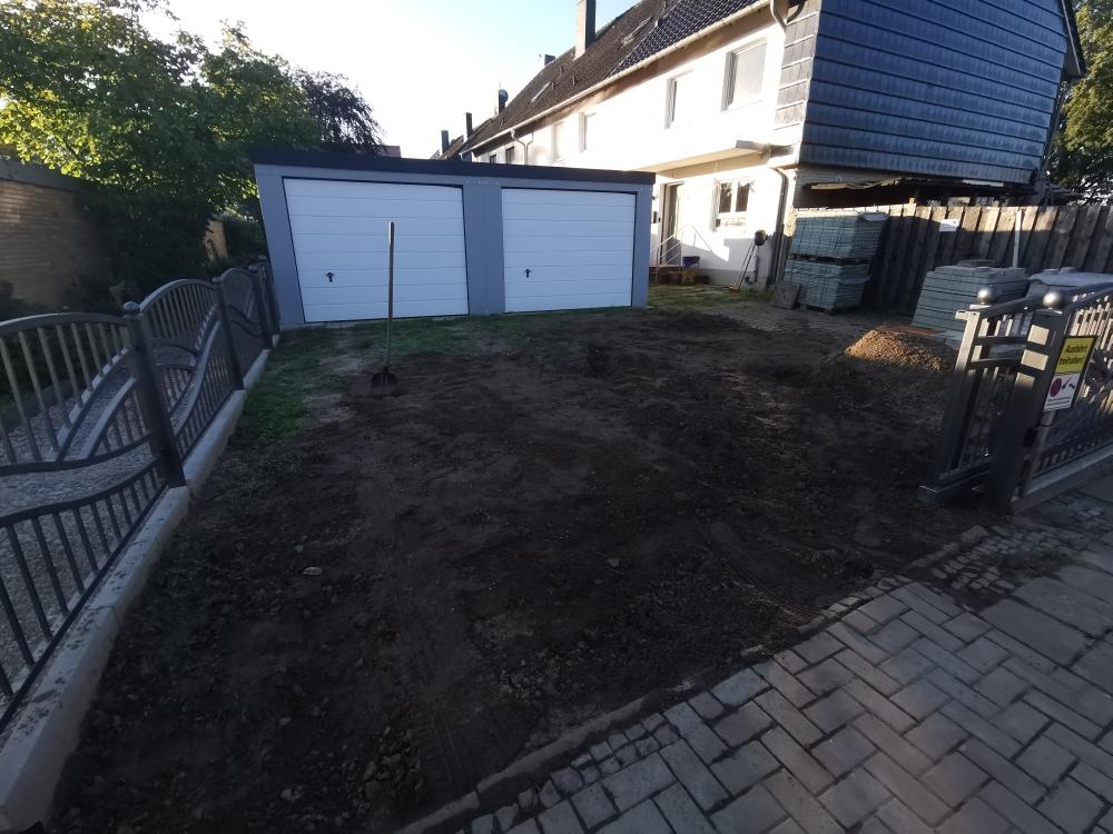 Vorbereitete Erdfläche nach Erdarbeiten vor einer Garage